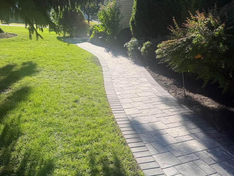 Curved paver walkway crossing a lawn