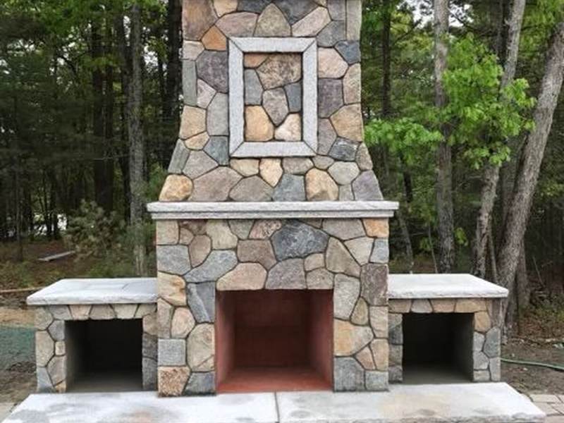Natural stone outdoor fireplace with wood storage