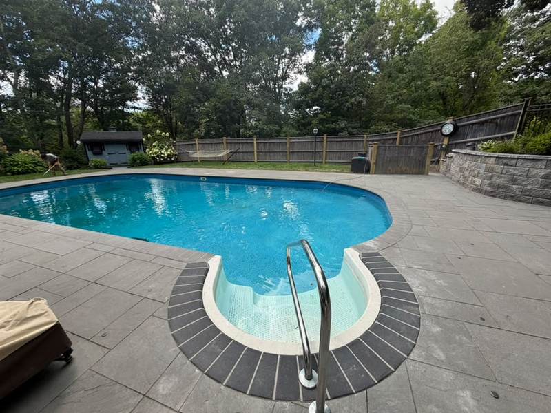 Pool deck finished in stone with a dark border
