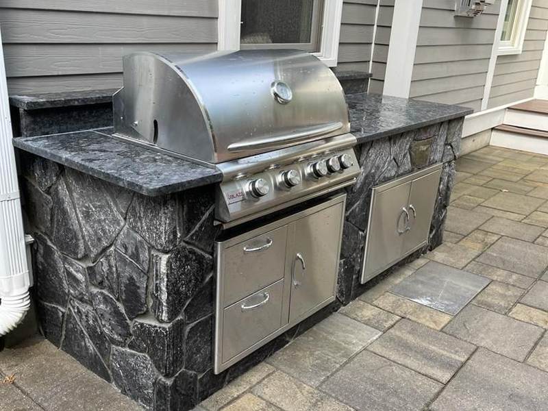 Outdoor kitchen with stainless grill and stone base