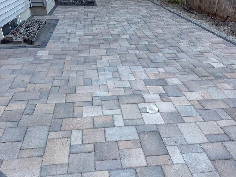 Large paver patio in a fenced back yard