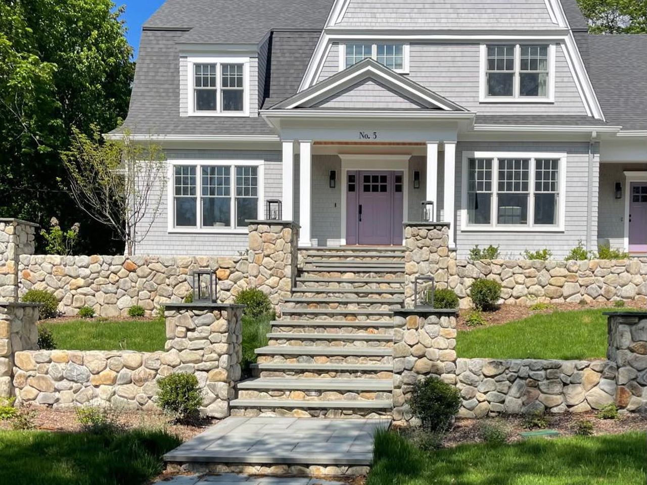 New England home with fieldstone retaining walls and bluestone steps built by HO International Masonry